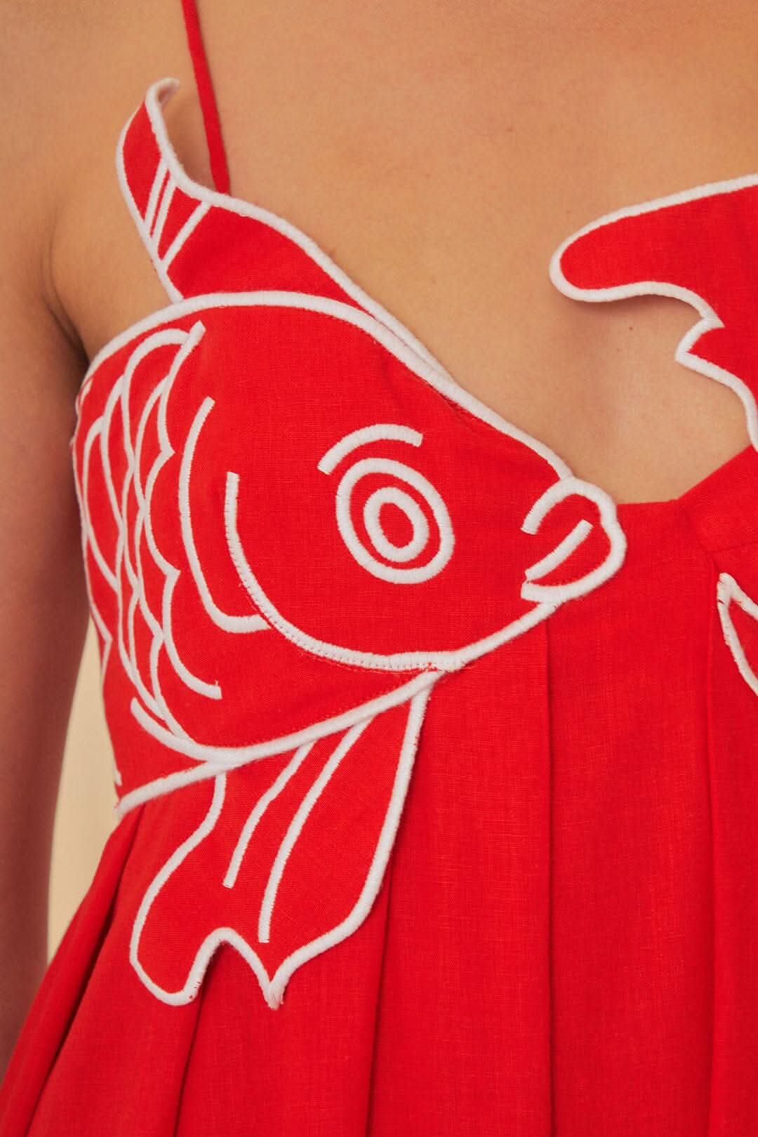 Detailed view of fish print pattern with white outline on red fabric