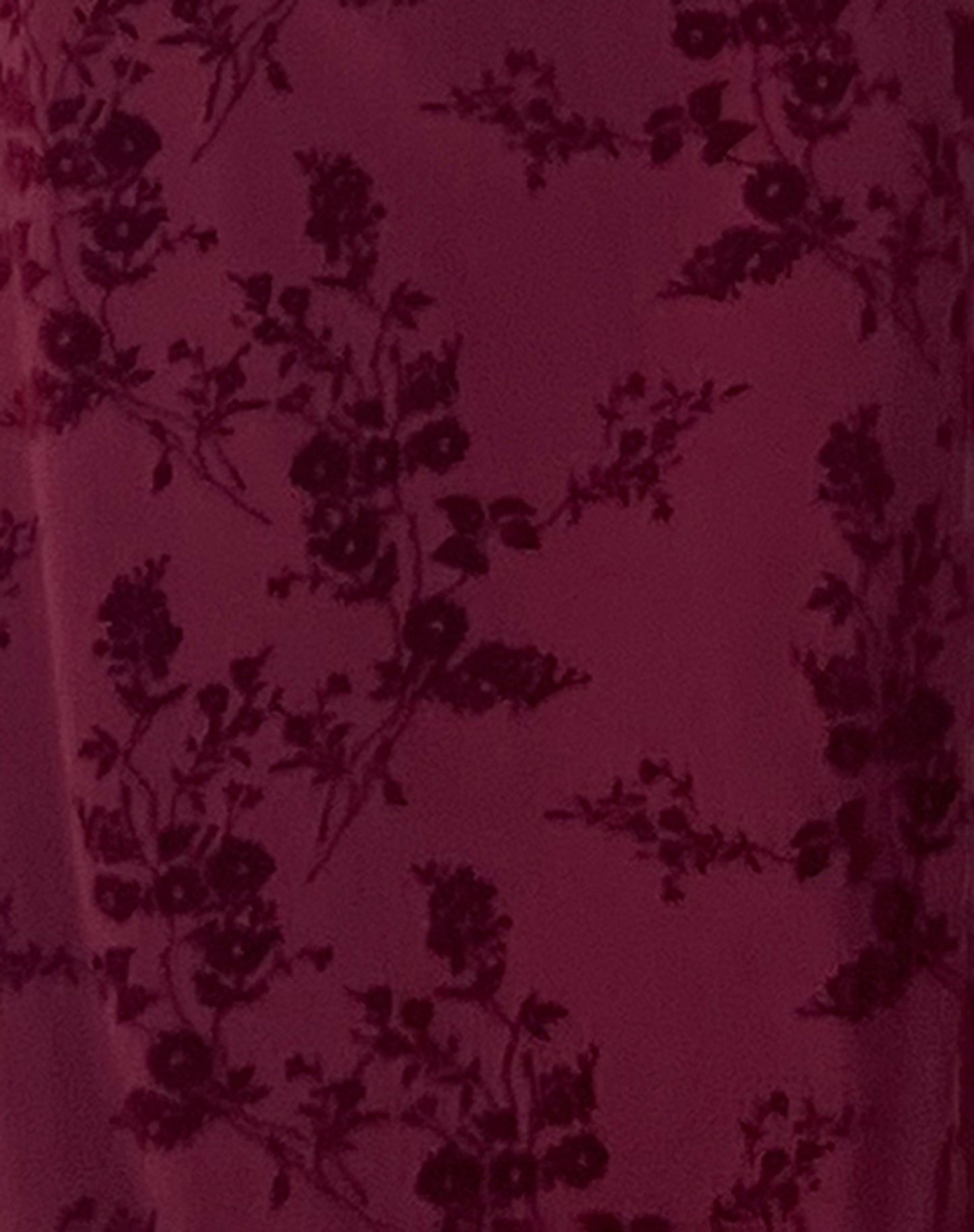 Burgundy velvet fabric with dark floral damask pattern close-up