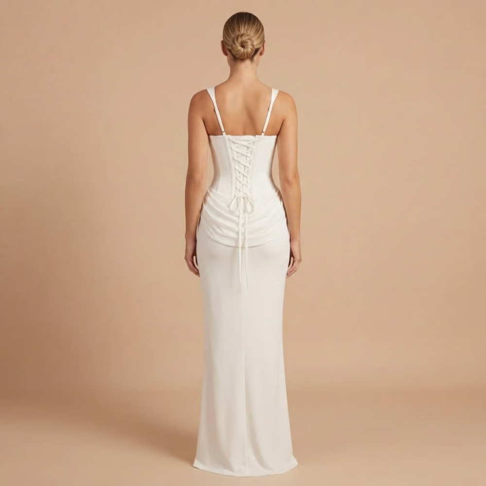 Back view of white ruched dress with lace-up corset closure