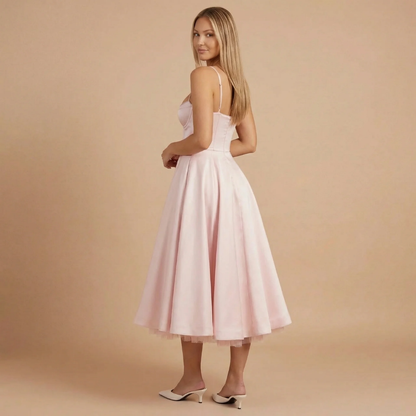 Back view of light pink A-line midi dress with spaghetti straps