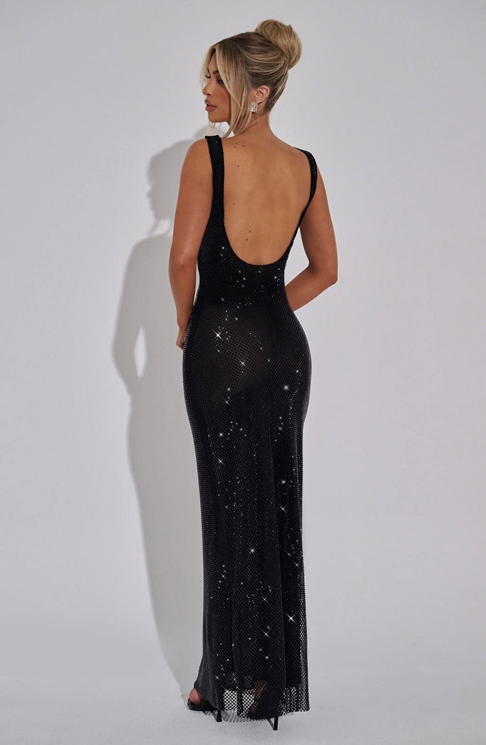 Back view of black sequin maxi dress with open back cutout