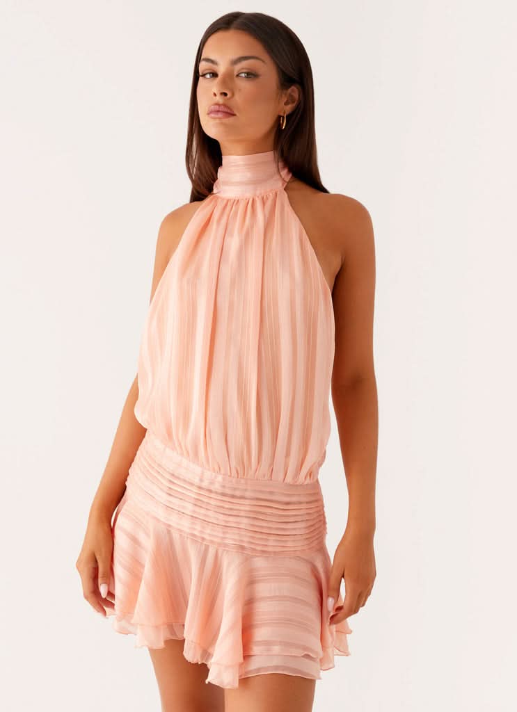 Peach pleated chiffon halter mini dress featuring gathered bodice and draped skirt