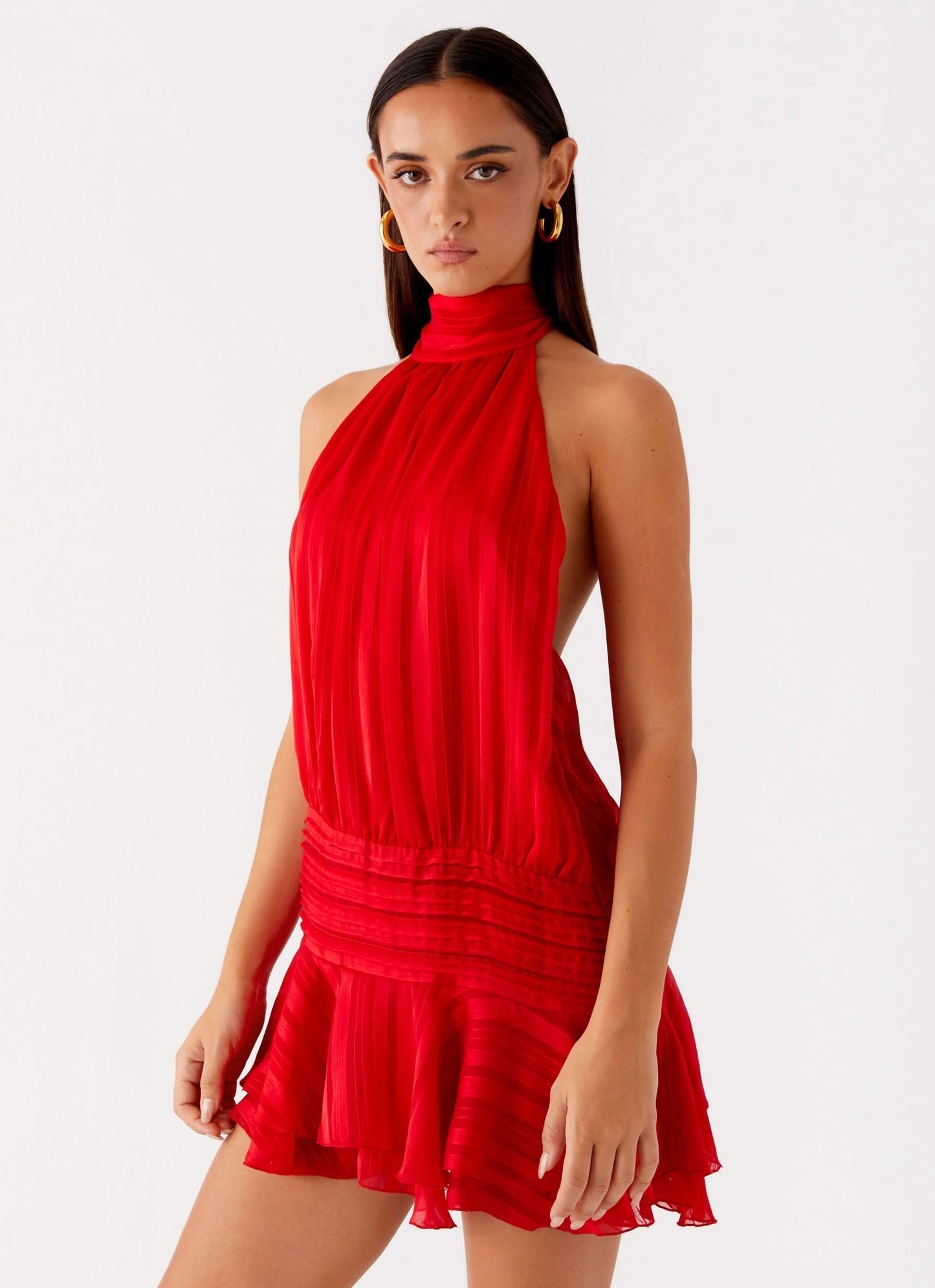 Red pleated chiffon halter neck mini dress with open back and flared hemline