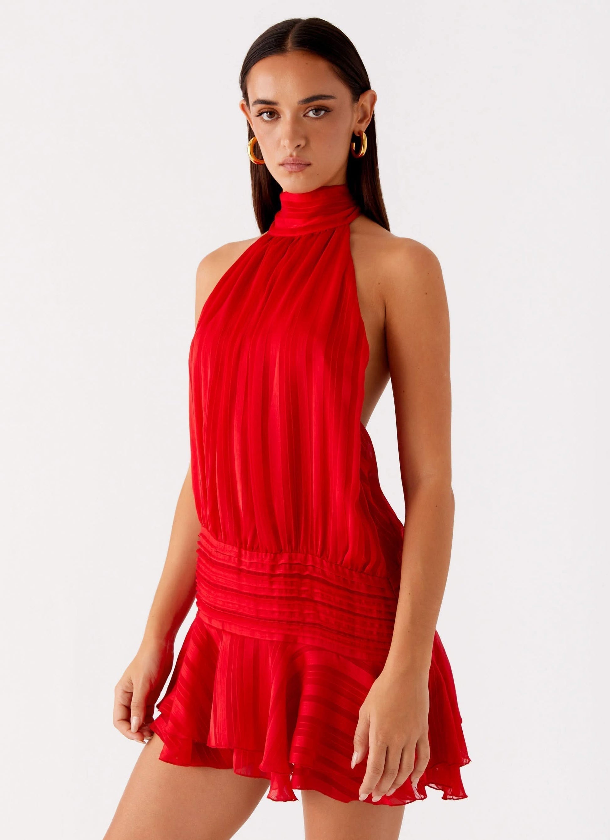 Red pleated chiffon halter neck mini dress with open back and flared hemline