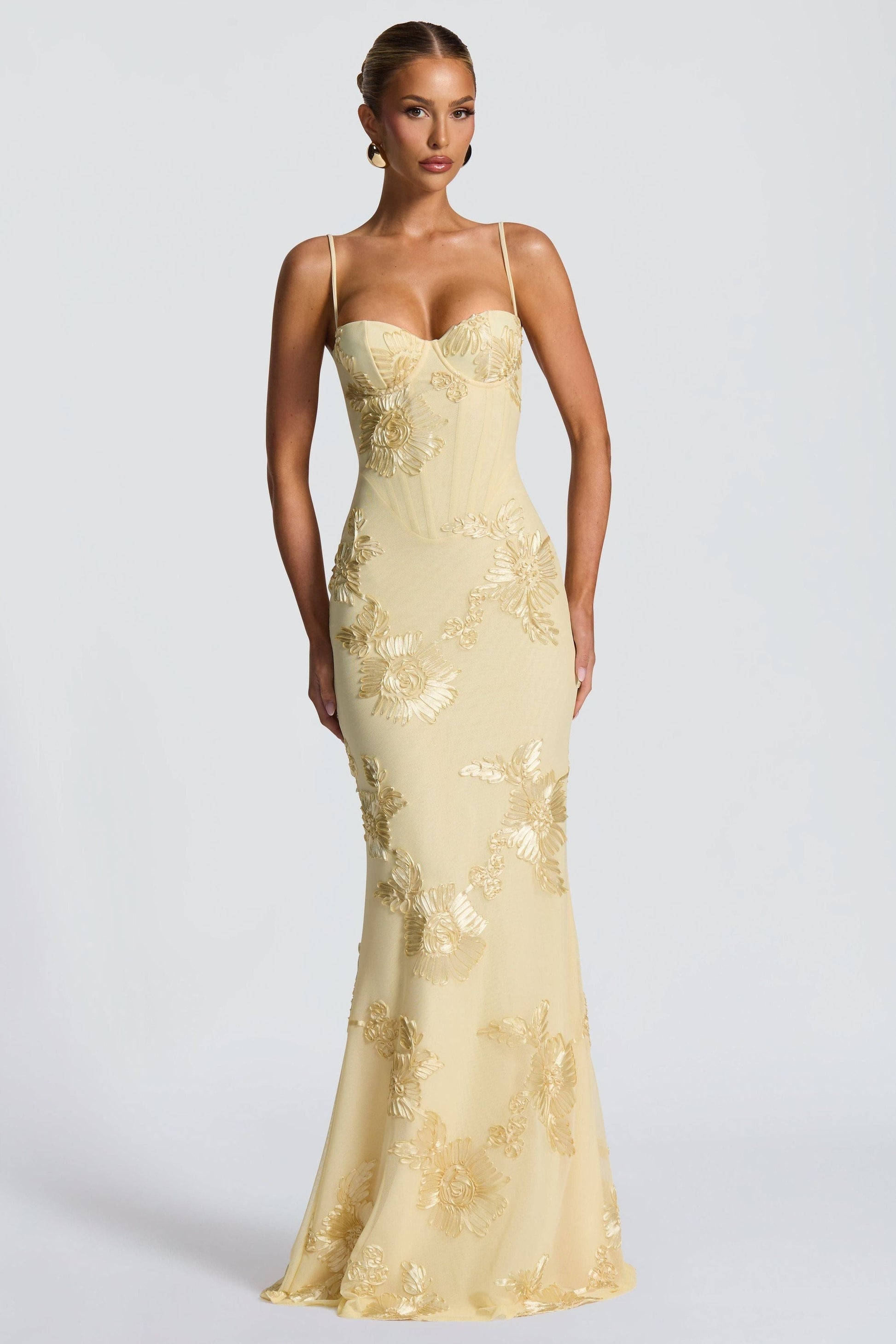 Fitted cream maxi dress featuring gold sunflower embroidery and spaghetti straps