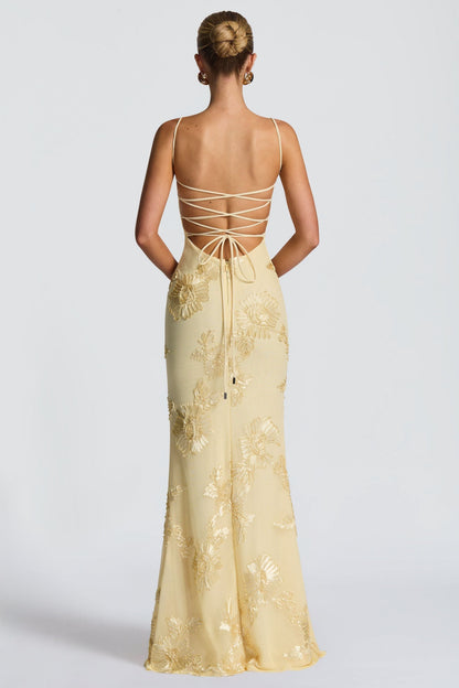 Back view of cream maxi dress with lace-up strappy back and gold floral details
