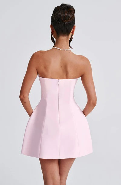 Back view of blush pink strapless A-line dress with center seam and voluminous skirt