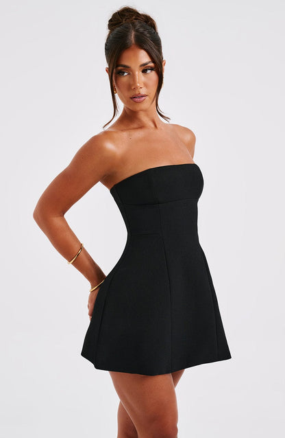 Black strapless mini dress side profile showing curved silhouette