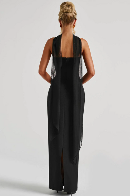 Back view of black strapless maxi dress with flowing draped scarf accent