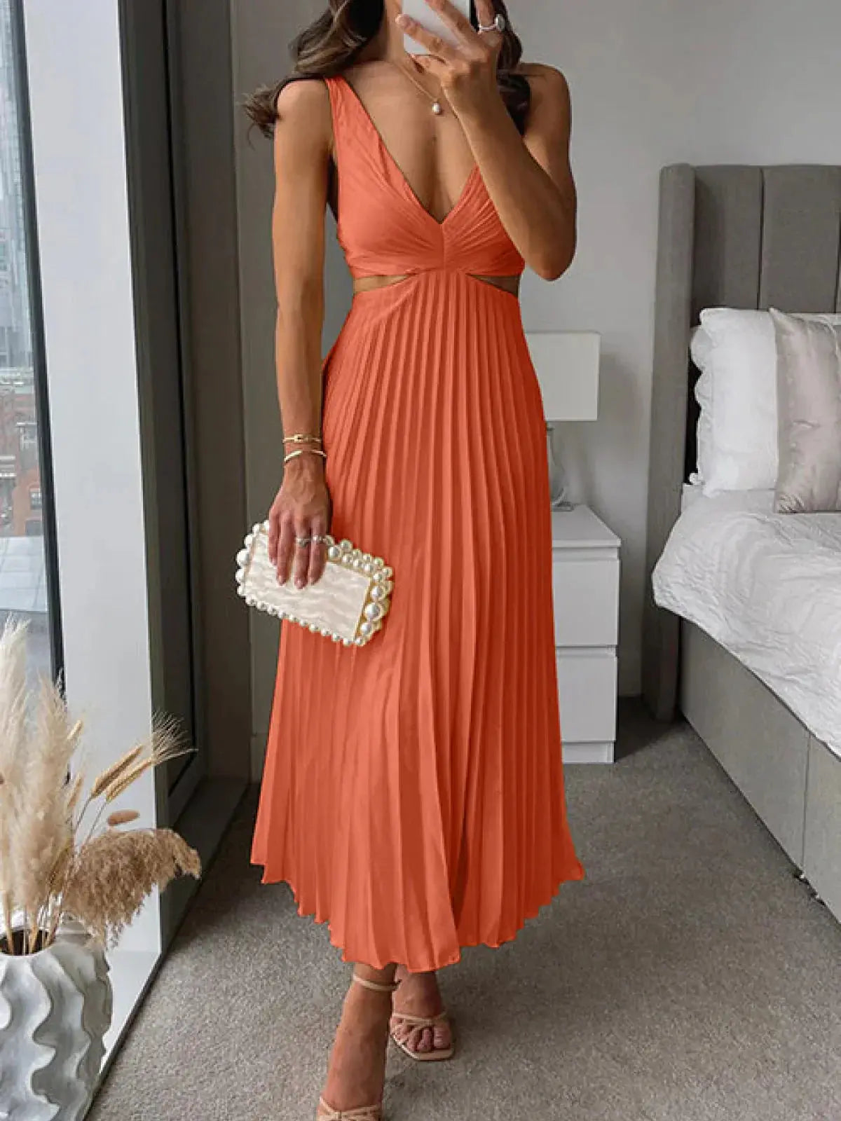 Coral pleated midi dress with v-neckline and cut-out waist design