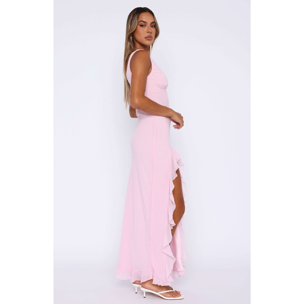 Side profile of pink maxi dress showing ruffled asymmetrical skirt