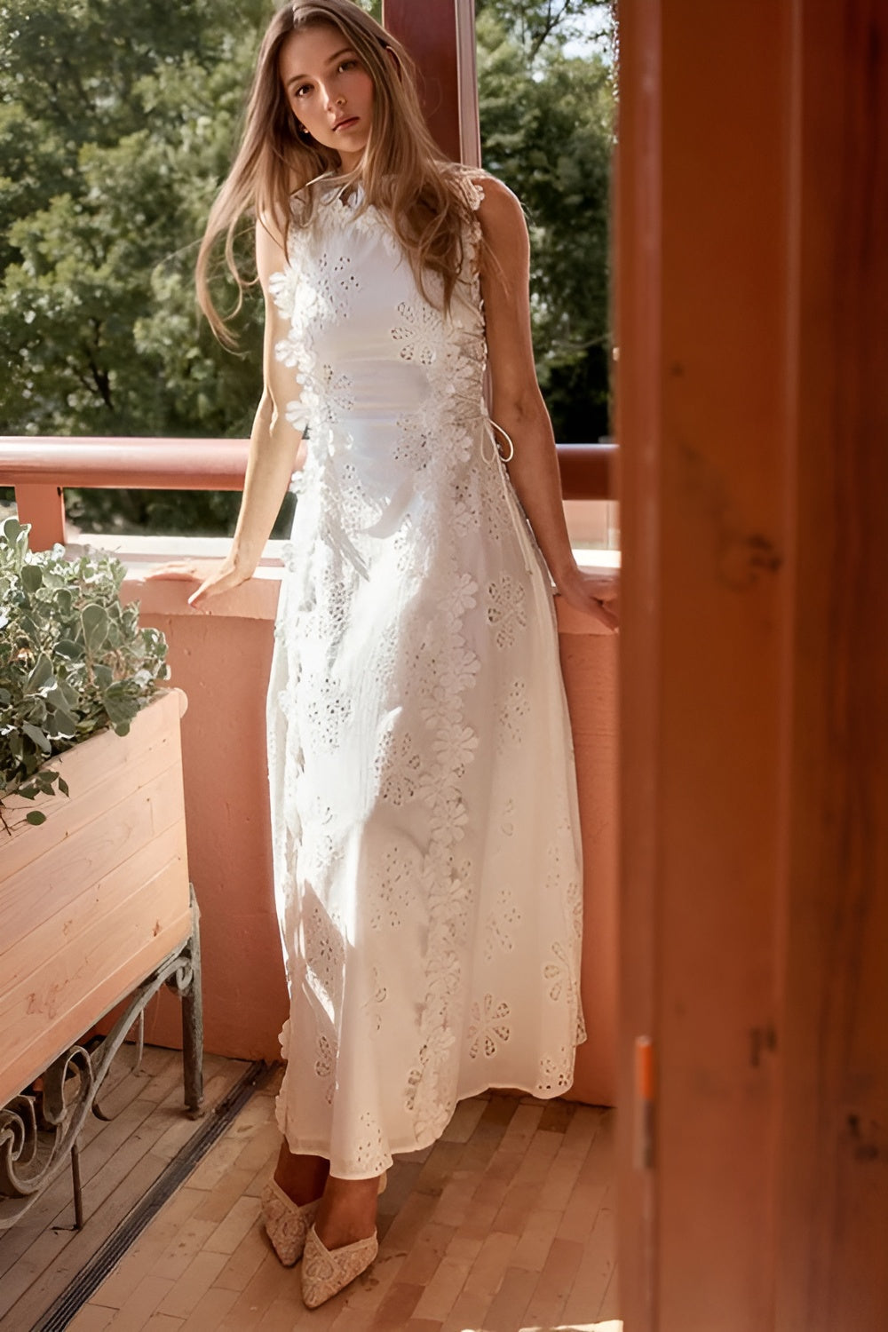 Cream eyelet lace maxi dress with ruffled neckline worn on outdoor balcony