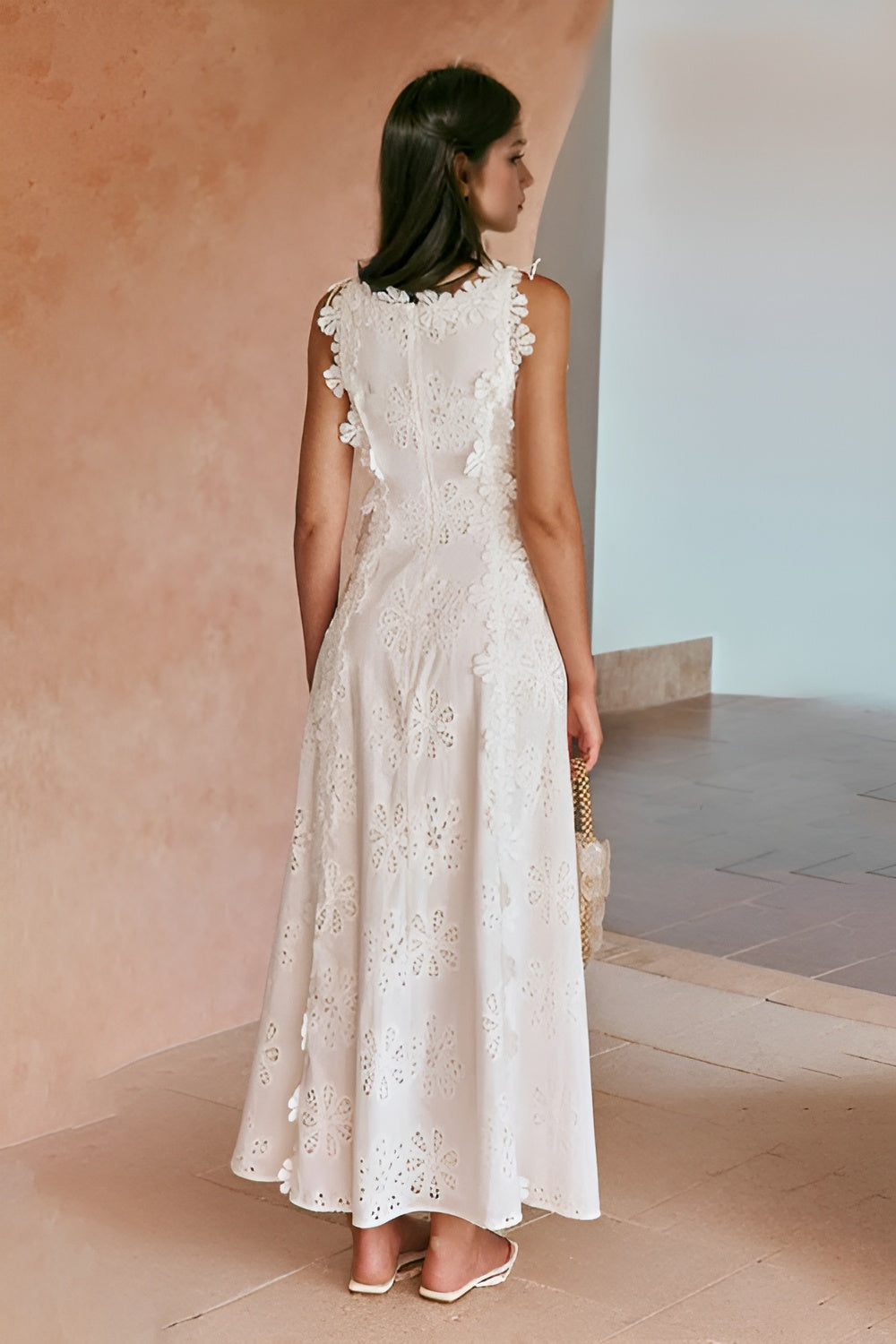 Rear view of white eyelet maxi dress with ruffled armholes and flowing skirt