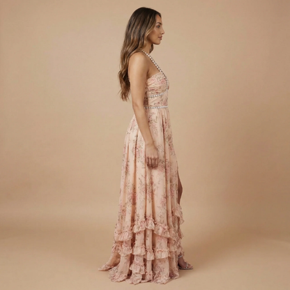 Side view of blush pink floral halter dress with tiered ruffled skirt