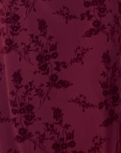 Burgundy velvet fabric with dark floral damask pattern close-up