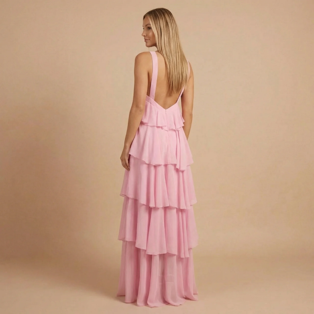Back view of pink halter maxi dress showing low V-back and layered tiered skirt