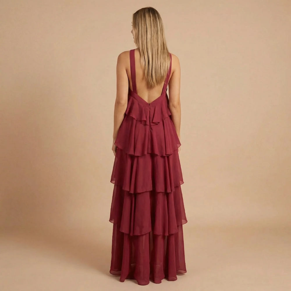 Back view of burgundy halter maxi dress displaying open back and stacked tiered design