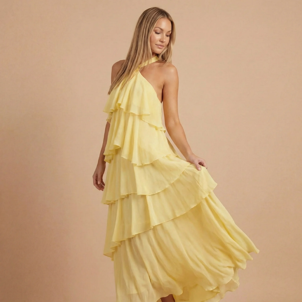 Pale yellow halter tiered maxi dress with flowing ruffled layers and twisted halter tie