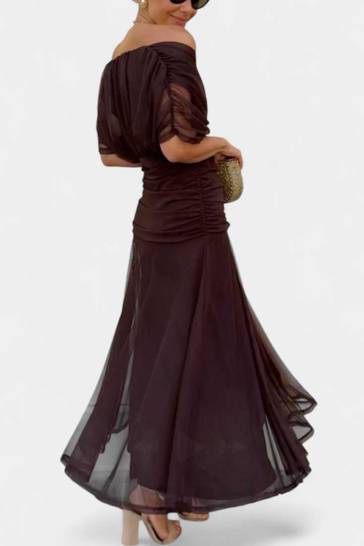 Back view of brown ruched midi dress with sheer overlay and curved hem
