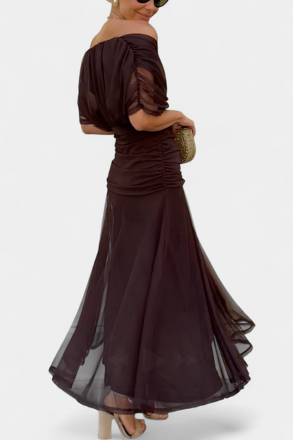 Back view of brown ruched midi dress with sheer overlay and curved hem