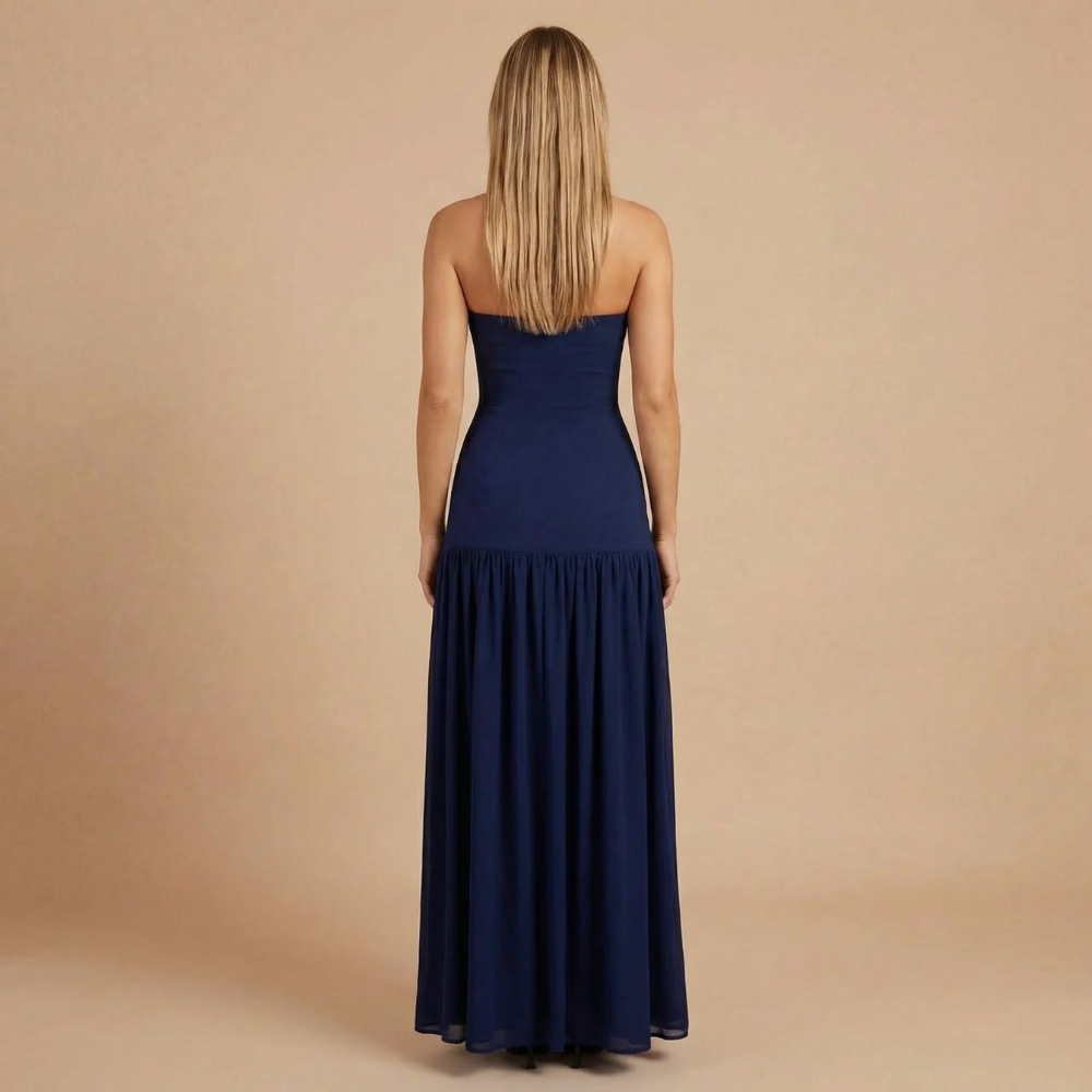 Back view of navy strapless maxi dress with fitted bodice and flowing skirt