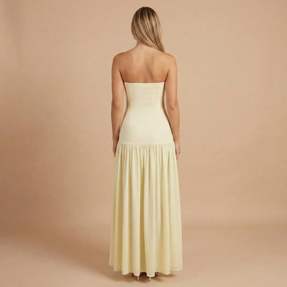 Back view of pale yellow strapless maxi dress with draped skirt