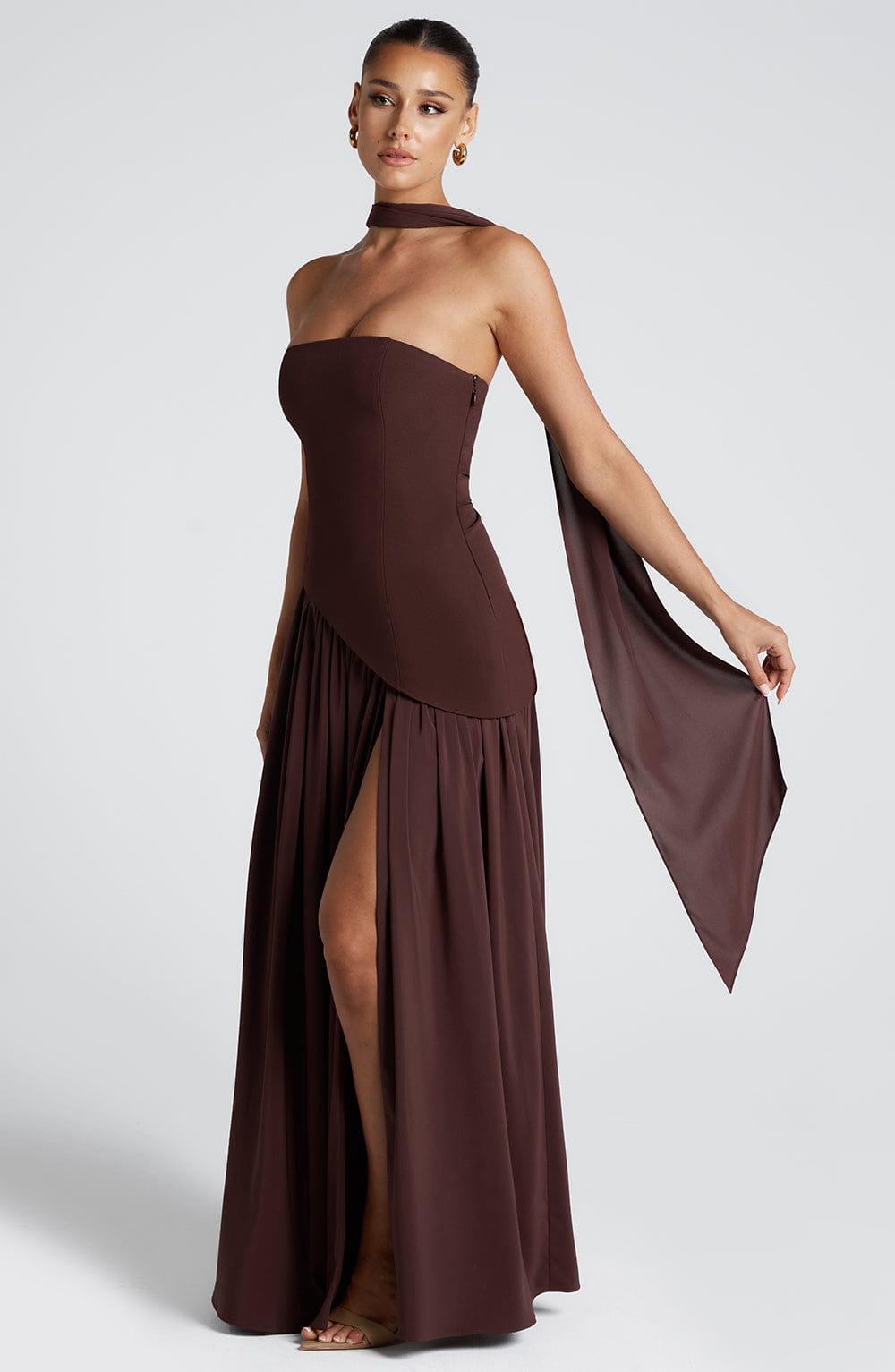 Brown strapless maxi dress with choker neckline, draped sleeve, and thigh slit