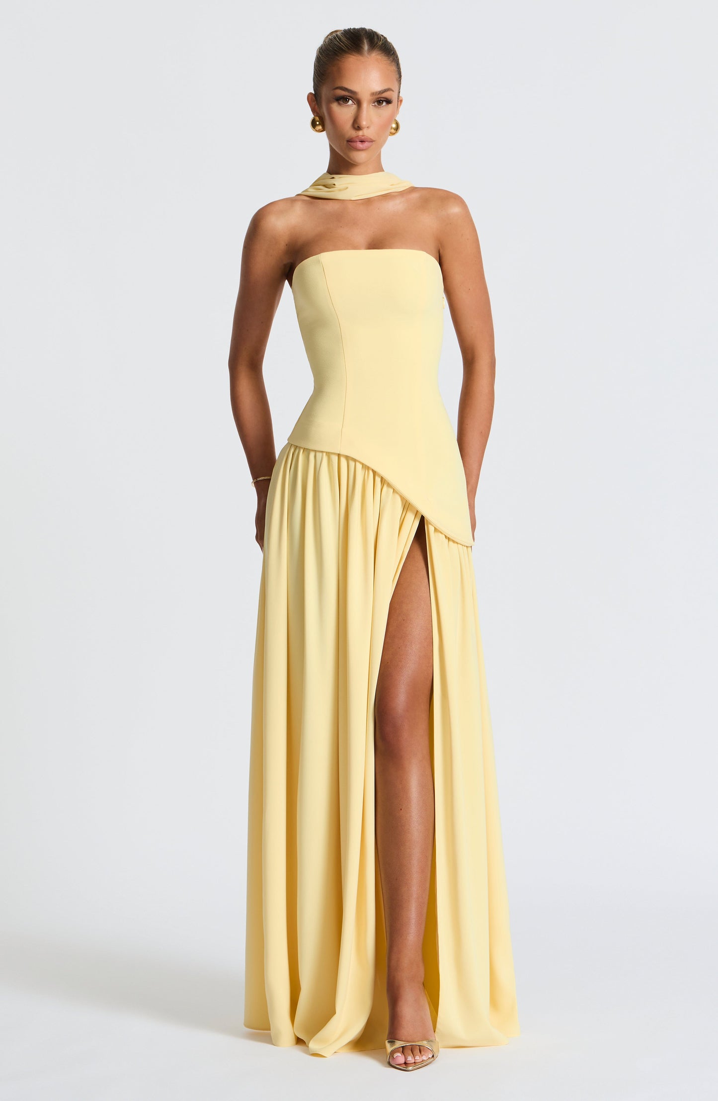 Pale yellow strapless maxi dress with asymmetrical pleated skirt and slit