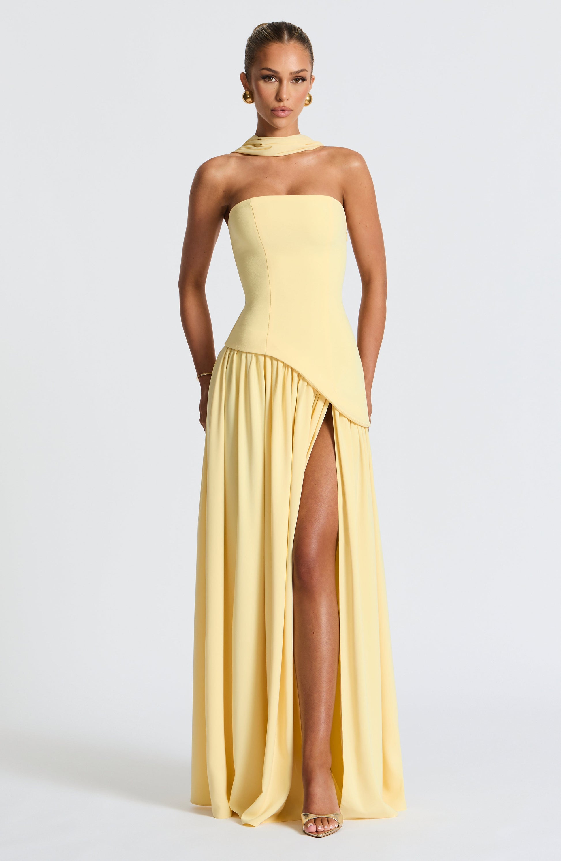 Pale yellow strapless maxi dress with asymmetrical pleated skirt and slit
