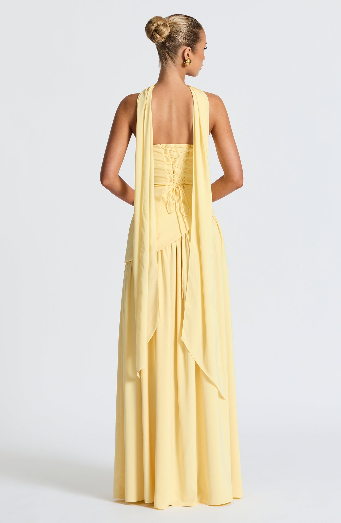 Pale yellow strapless maxi dress back view with corset detail and slit