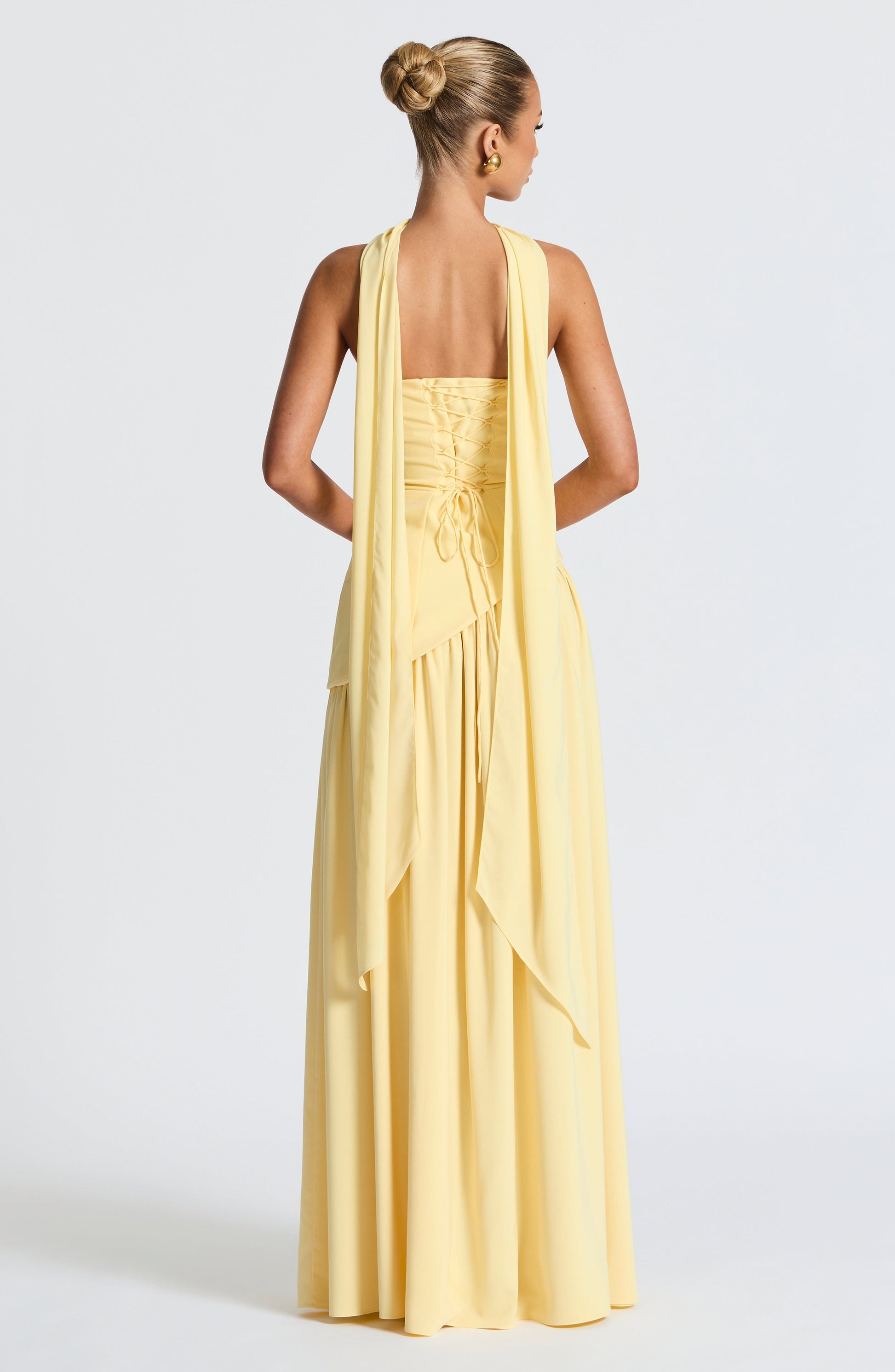 Pale yellow strapless maxi dress back view with corset detail and slit