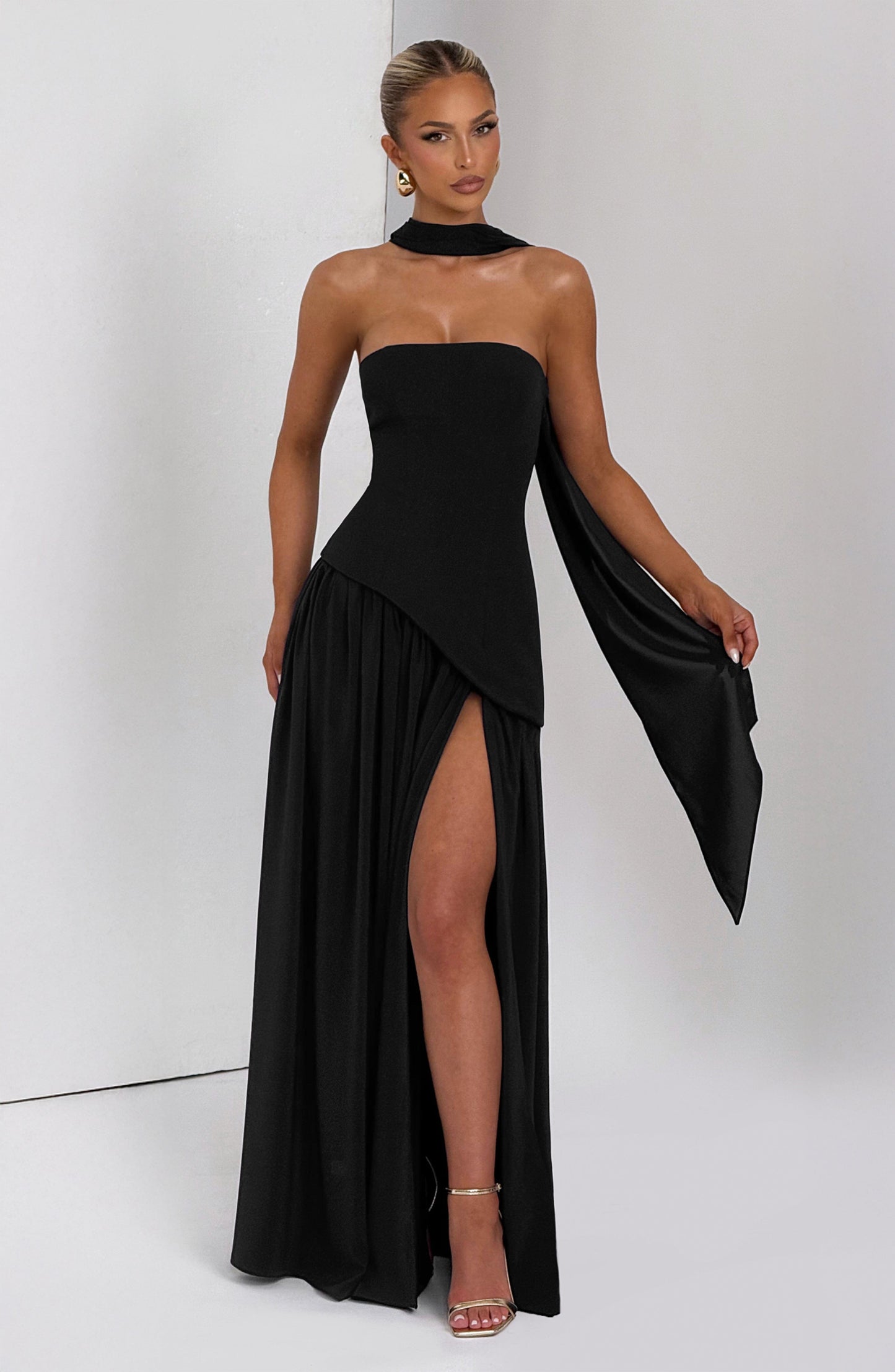 Black strapless maxi dress with asymmetrical draped sleeve and thigh slit