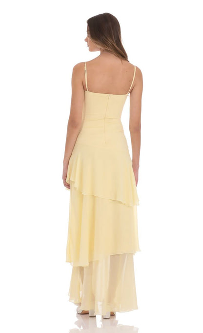 Back view of pale yellow maxi dress showing spaghetti straps and layered chiffon hem